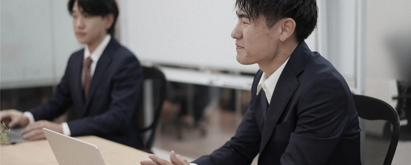 会議室でノートパソコンを開いて商談するメンバー